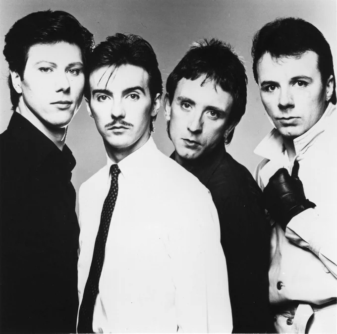 Promotional image of Ultravox circa 1984, featuring Midge Ure and band members in a black-and-white studio portrait during the Lament era.