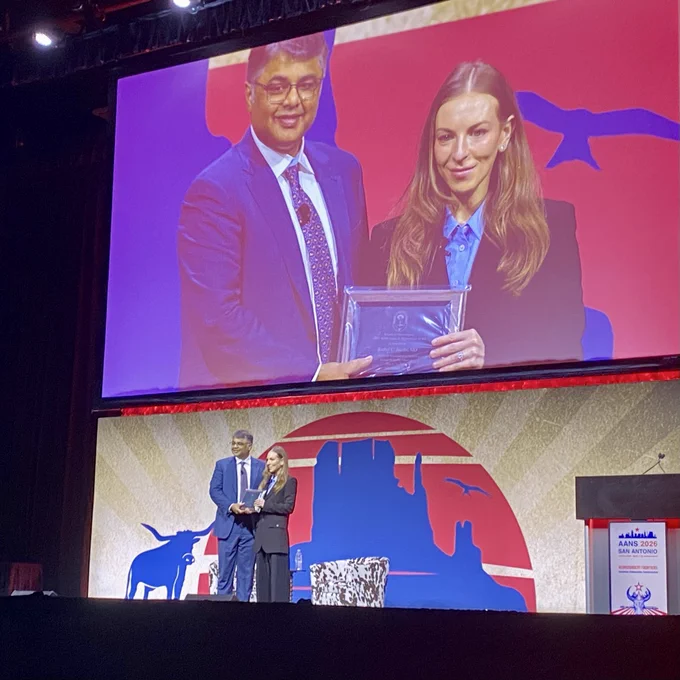 Praveen Mummanei, MD, presents the award to Rachel Jacobs, MD.
