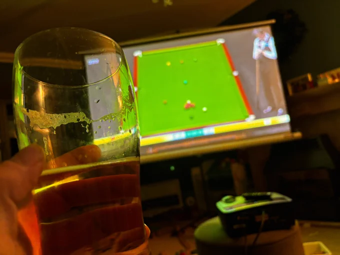 A photo of a projector screen showing the snooker and a beer in the foreground - in my lounge