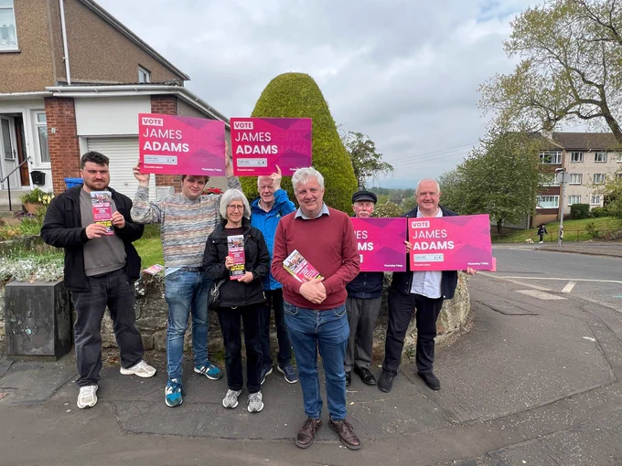 James Adams with Scottish Labour campaigners who are holding big James Adams placards