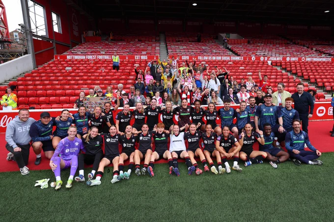 Southampton FC Women's players and staff take a group photo with Southampton supporters in the stands at Nottingham Forest's City Ground