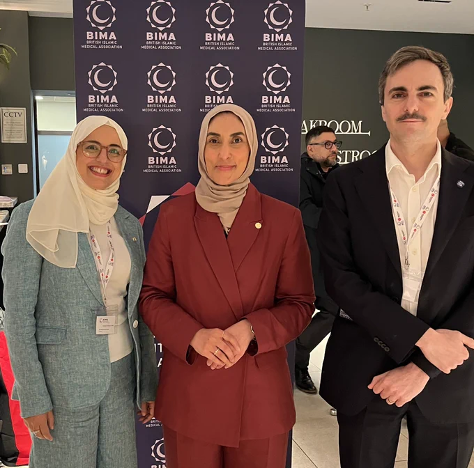 Dr Shehla Imtiaz-Umer, Dr Sahira Dar and me standing in front of a BIMA display
