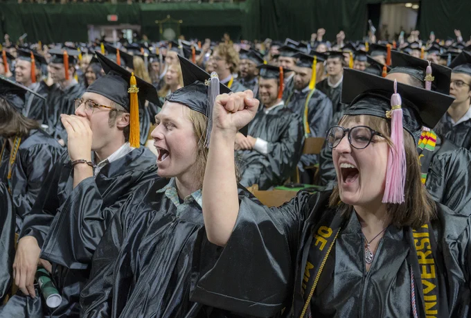 Graduates seated and cheering