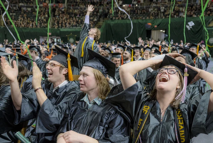 Graduates celebrating under falling confetti streamers