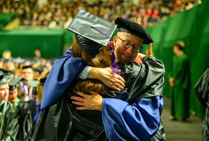 Graduate hugging a faculty member