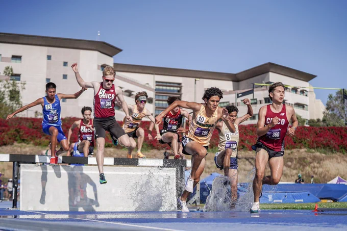 The steeplechase field jumping over a water jump. Sharvin is pictured in the middle of the pack.