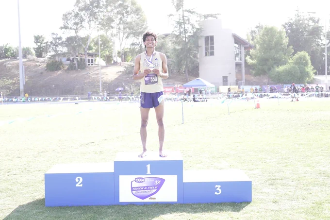 Sharvin is standing on top of the podium with his first place medal.