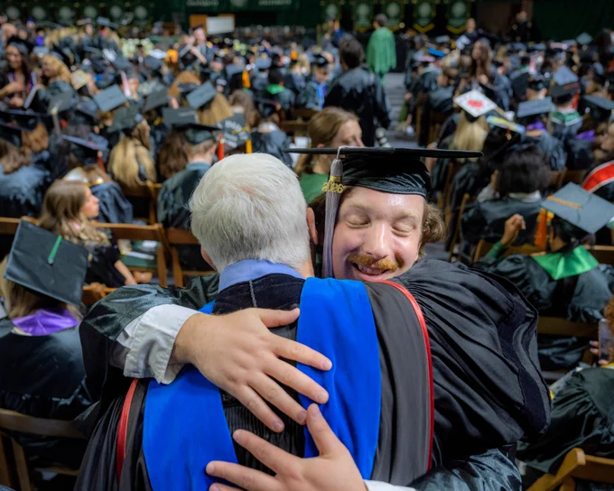 Ohio University graduate hugs a professor.