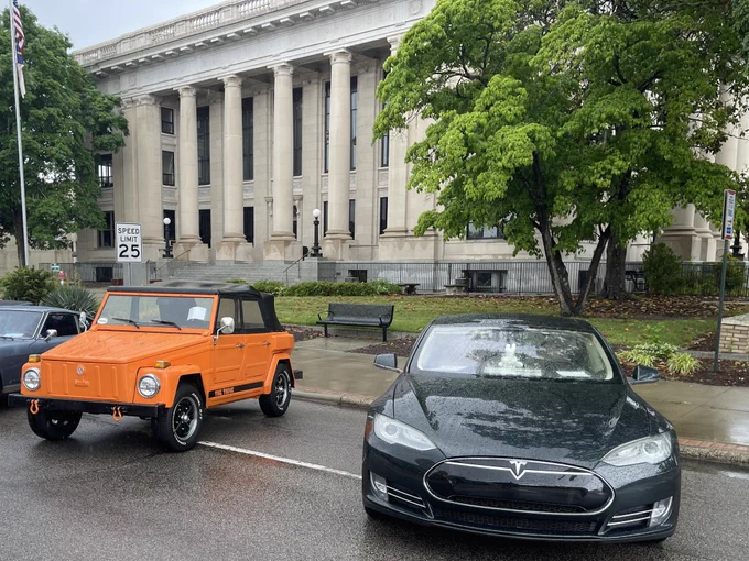 Saturday, May 2, 2026, downtown Smithfield, NC. Pictured left to right is an orange 1974 Volkswagen Thing and a Metallic Sequoia Green 2012 Model S. In the background is the Johnston County Courthouse. The 40th Annual Ham & Yam Festival held a car show hosted by the Southland Car Club. Only EV registered.