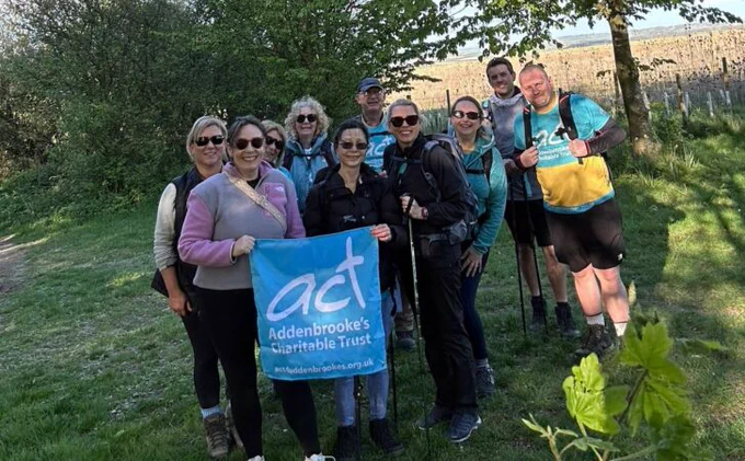 Group of walkers holding a banner for Addenbrooke's Charitable Trust during an outdoor event.