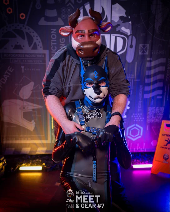 A blue shiny dog on his knees protected by a cow standing behind him and holding its shoulders