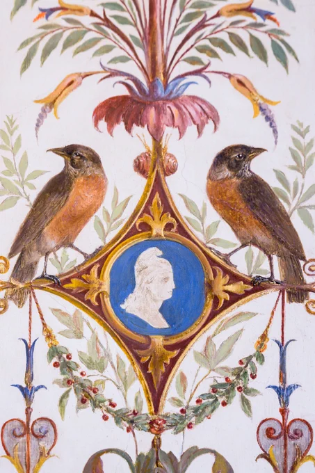 Ornate painting with two birds perched on either side of a central medallion featuring a white profile silhouette of a person on a blue background. The design includes floral and decorative elements in rich colors.