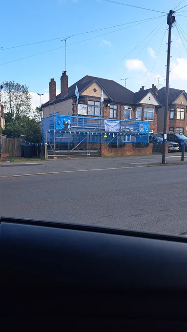 House in Coundon in the parade route, with a scaffold viewing platform on the drive & garden. Adorned with city flags & blue meshing 