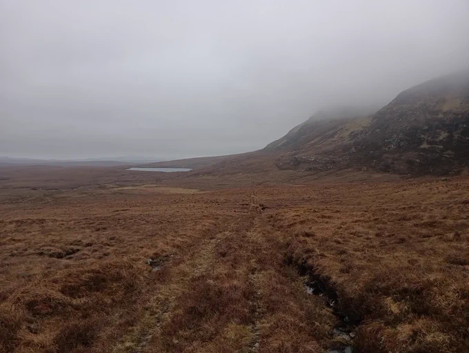 Bleak moor, crags, mist and lochan