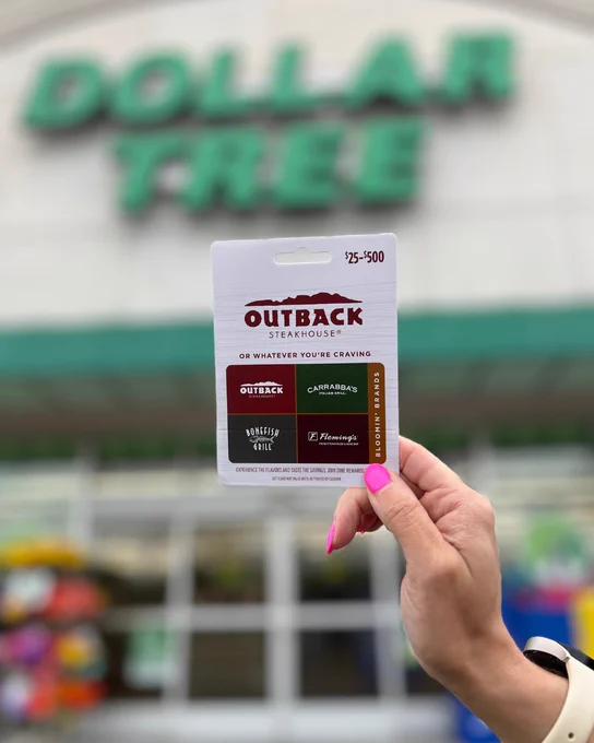 Hand holding an Outback Steakhouse gift card in front of a Dollar Tree store entrance.
