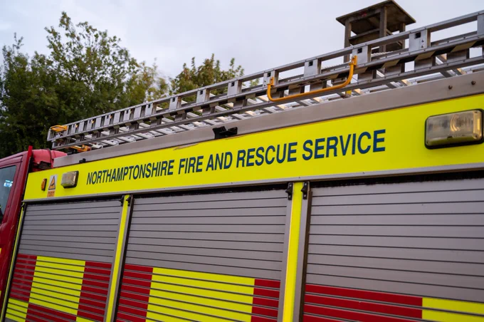 Northamptonshire Fire and Rescue Service appliance with a ladder on the roof. Features yellow text on a bright yellow stripe.