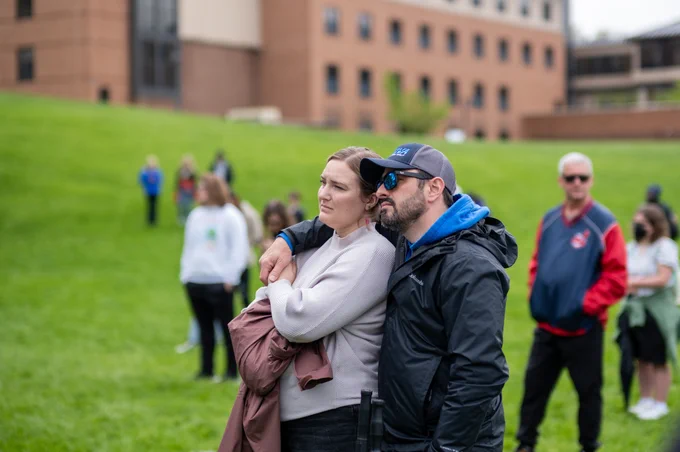Two people listen to a speaker while standing together during the May 4 Commemoration. 