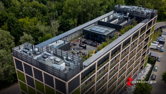 Exterior view of CD PROJEKT RED’s headquarters, featuring exterior green wall panels of plants and a rooftop with seating.