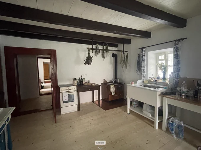 the kitchen with brown beams and wood floor