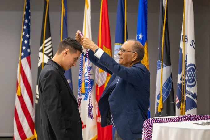 President Tripathi presents military cords to an honoree at UB's Veteran and Military Cord Celebration.
