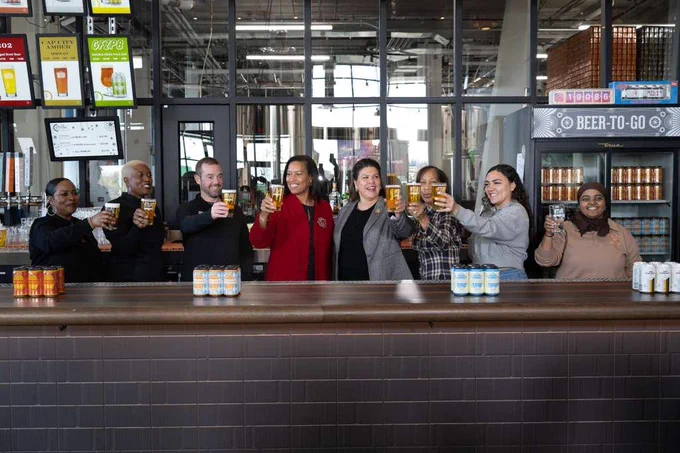 Mayor Bowser, Deputy Mayor Nina Albert, and Director Rosemary Suggs Evans gesture “cheers” with local business representatives.