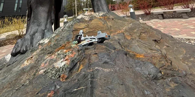 A Star Wars Lego set featuring the Mandalorian and Baby Yoda sits underneath the Husky Statue on Michigan Tech’s campus. 
