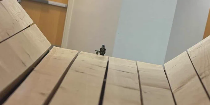 A Lego Mandalorian and Baby Yoda stand together at the end of a wooden display on Michigan Tech’s campus. 