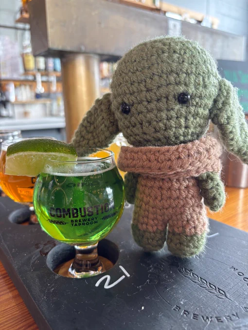 A green beer with a crochet star wars Grogu doll