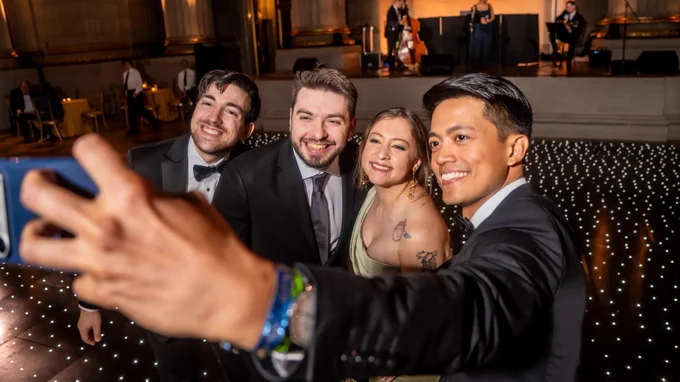 Farrell Moskow, far left wearing a tuxedo, takes a group selfie with other graduate students at GradGov's Grad Gala.