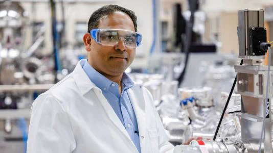 Rajeev Surendran Assary pictured inside of an Argonne lab, wearing PPE.