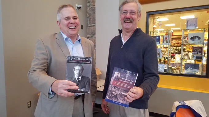 Two males holding history books