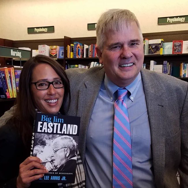 Female holding a book reading Big Jim Eastland standing next to a male