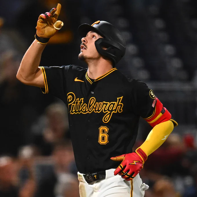 Konnor Griffin points upward while crossing home plate after hitting a home run. He is wearing a black Pittsburgh Pirates jersey and a black batting helmet.