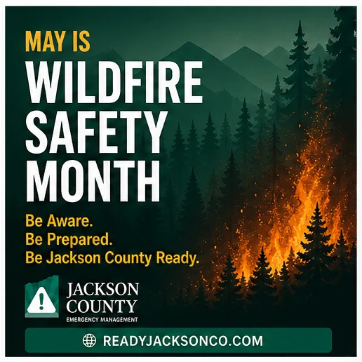 Graphic with forest wildfire background and bold text reading “May is Wildfire Safety Month. Be Aware. Be Prepared. Be Jackson County Ready.” Includes Jackson County Emergency Management logo and website readyjacksonco.com.