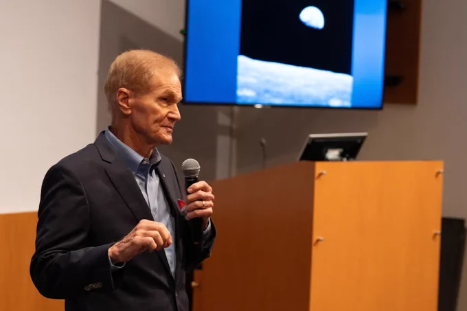 Older man in a suit holding a microphone at a lectern, speaking while a screen behind him shows the moon and lunar surface.

Our research professor and TRACE Lab director at UCF’s Institute for Simulation and Training, Shawn Burke, Ph.D., is featured in this article, where she explores the complexities of team dynamics in space.