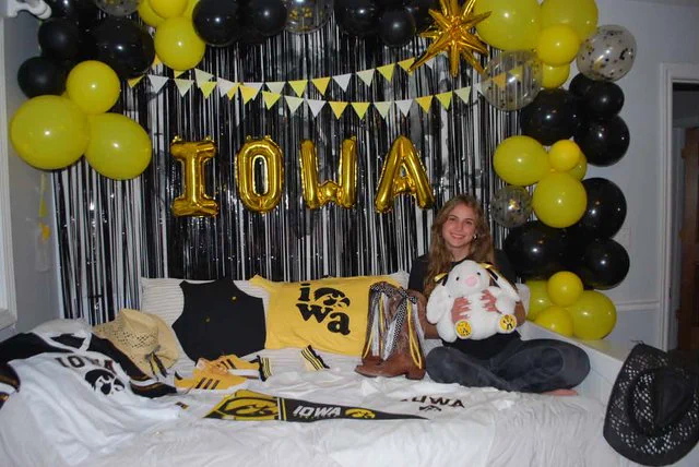 Student surrounded by Iowa gear.