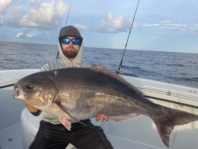 Fishing captain holding a barrelfish on a boat in the Florida Keys