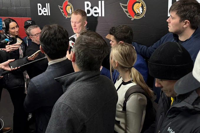 Pierce and other members of hockey media interviewing Ottawa Senators caption Brady Tkachuk