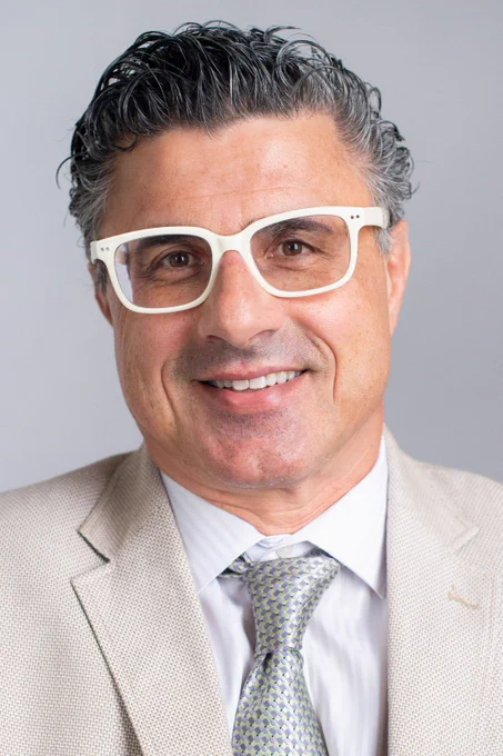 Aurelio Galli, Ph.D., D.Sc., stands in front of a gray background.