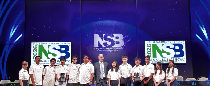 The high school and middle school winning teams of the National Science Bowl finals posing on stage with their trophies and the Secretary of Energy Chris Wright.
