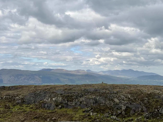 Looking across Maebh’s Gap towards the eastern summit trig point of Barnavave, with the high Mournes beyond.