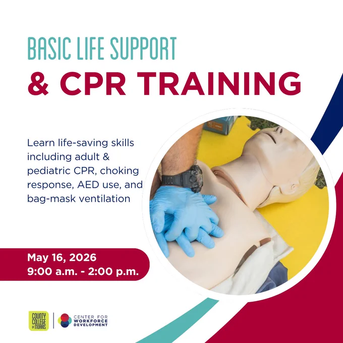 Hands wearing blue gloves performing CPR chest compressions on a training mannequin during a life support course.