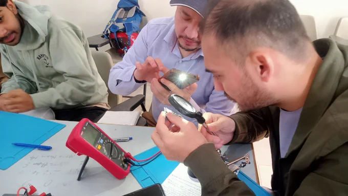 mobile repairing student performing practical in class room