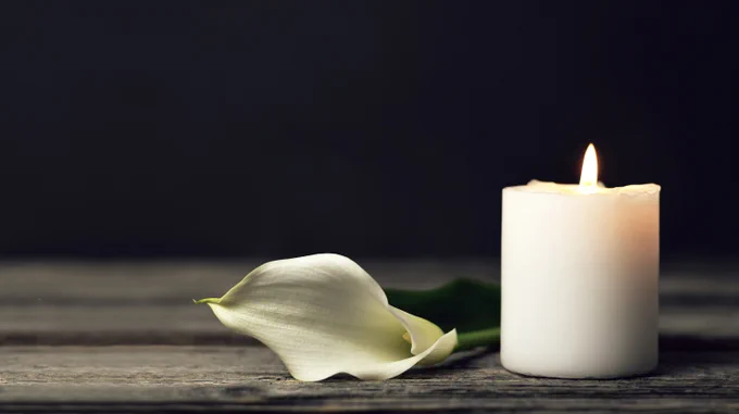A white lily and a lit candle