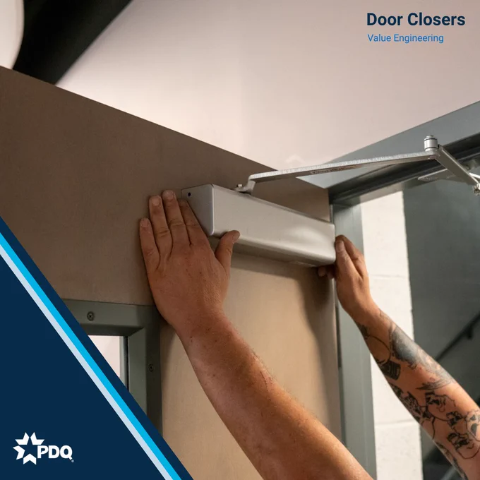 A technician installs a door closer onto a commercial door frame. Text reads: Door Closers — Value Engineering. PDQ logo in corner."