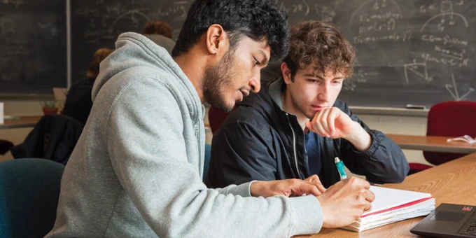 Two Michigan Tech students study together in a classroom. 