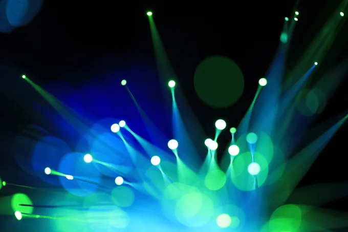 Luces de fibra óptica verdes y azules con destellos sobre fondo negro