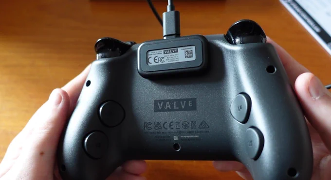 The back of the controller, with four back buttons, and the magnettic puck connected to the top to charge.
