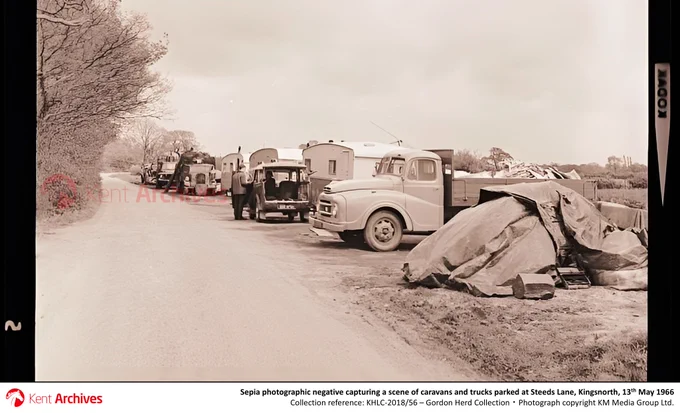 Shown here is a sepia photographic negative capturing a scene of caravans and trucks parked at Steeds Lane, Kingsnorth, 13th May 1966 [collection ref. KHLC-2018/56]. Photograph copyright KM Media Group Ltd.

About the talk:
Kent has the UK’s biggest Gypsy/Traveller population and was at the forefront of efforts to address the accommodation crisis facing these communities in the post-war period. This talk will examine the impact and implementation of the 1960 and 1968 (Pt. II) Caravan Acts in Kent, focusing especially on Maidstone, and will use local authority and press sources to consider the factors determining who, where and how itinerants were accommodated and their enduring impacts at the local level.

Dr David Smith is a Reader in Social Policy. His research aims to document the experience of minority and underprivileged communities including Roma, Gypsies and Travellers, foreign workers in the NHS, and working class localities affected by public policy and housing development.