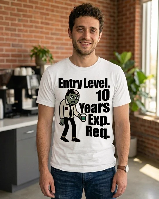 A cartoon illustration of a green-skinned zombie wearing a rumpled white dress shirt and a black necktie. The zombie has large, wide, bloodshot eyes and a dazed expression, holding a disposable coffee cup with a green sleeve. To the right of the zombie, the text reads "Entry Level. 10 Years Exp. Req." in a bold, outlined font. The entire design has a slightly distressed, vintage texture.